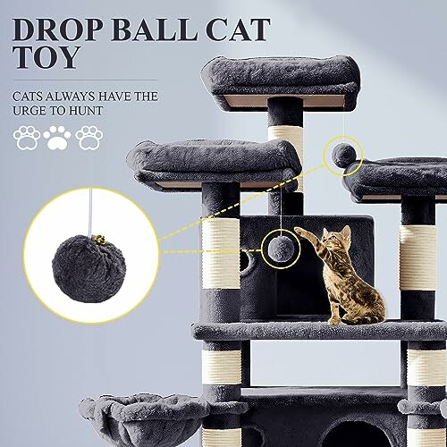 Cat playing with drop ball toy on cat tree